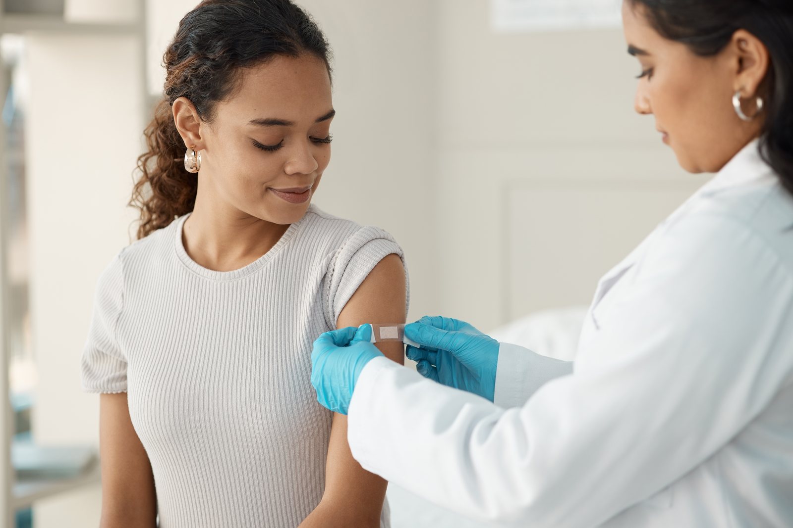 Enfermera colocando una curita en el brazo de una paciente después de aplicar una vacuna en Vacuna360 Monterrey